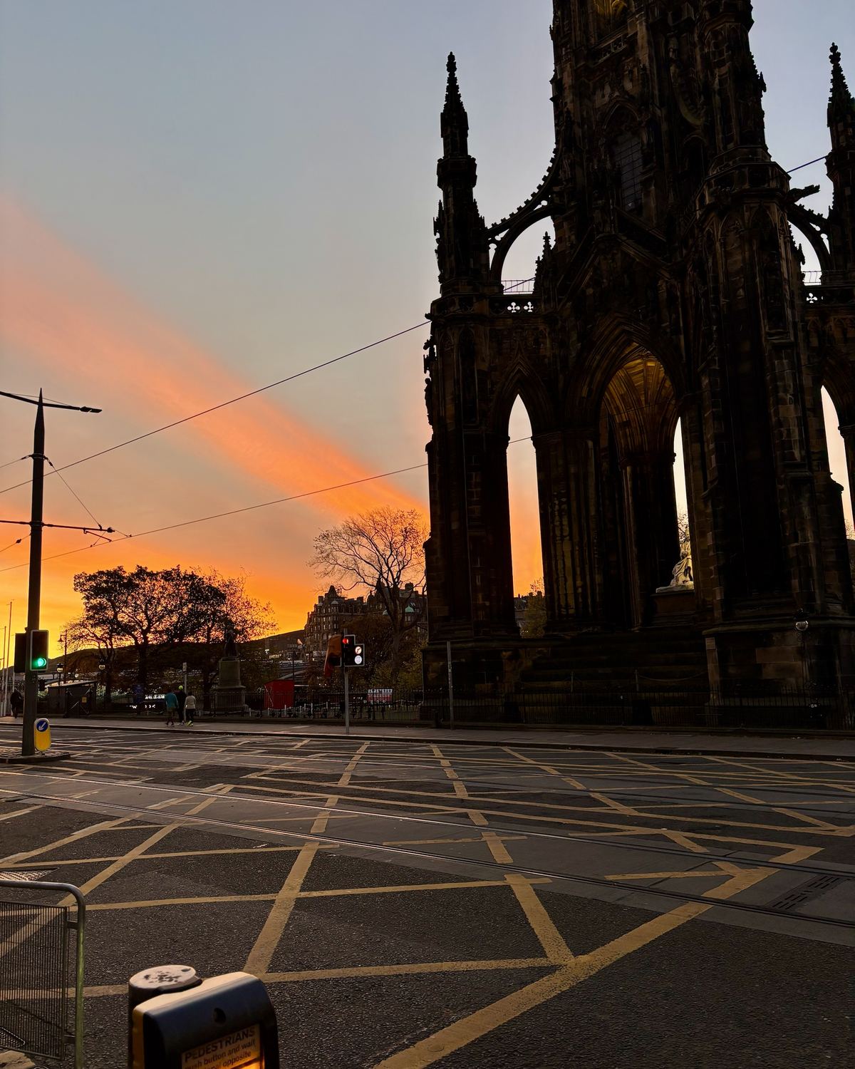 Het Scott Monument tegen een oranje lucht bij zonsondergang