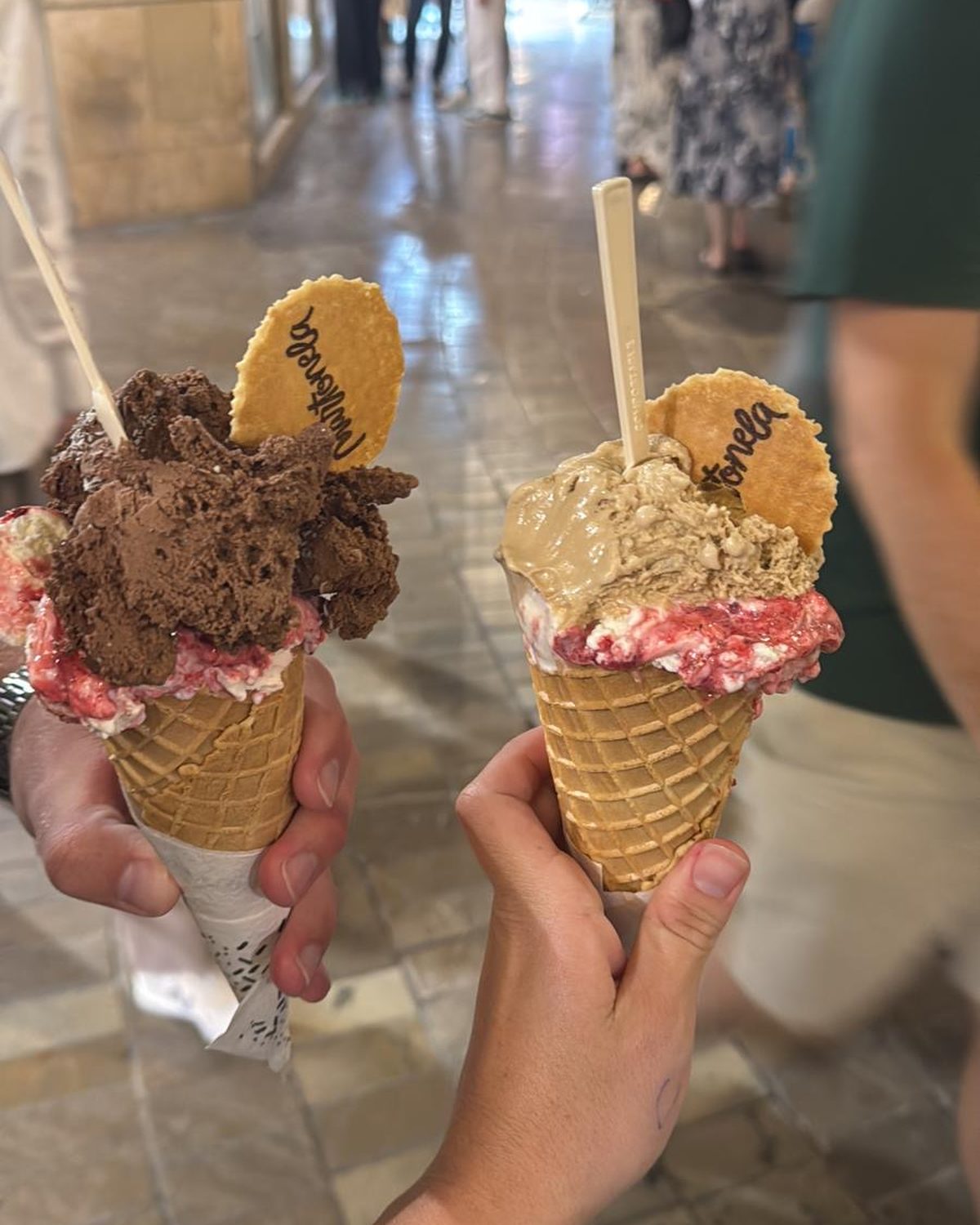 Twee hoorntjes met ijs in een drukke winkelstraat in Málaga