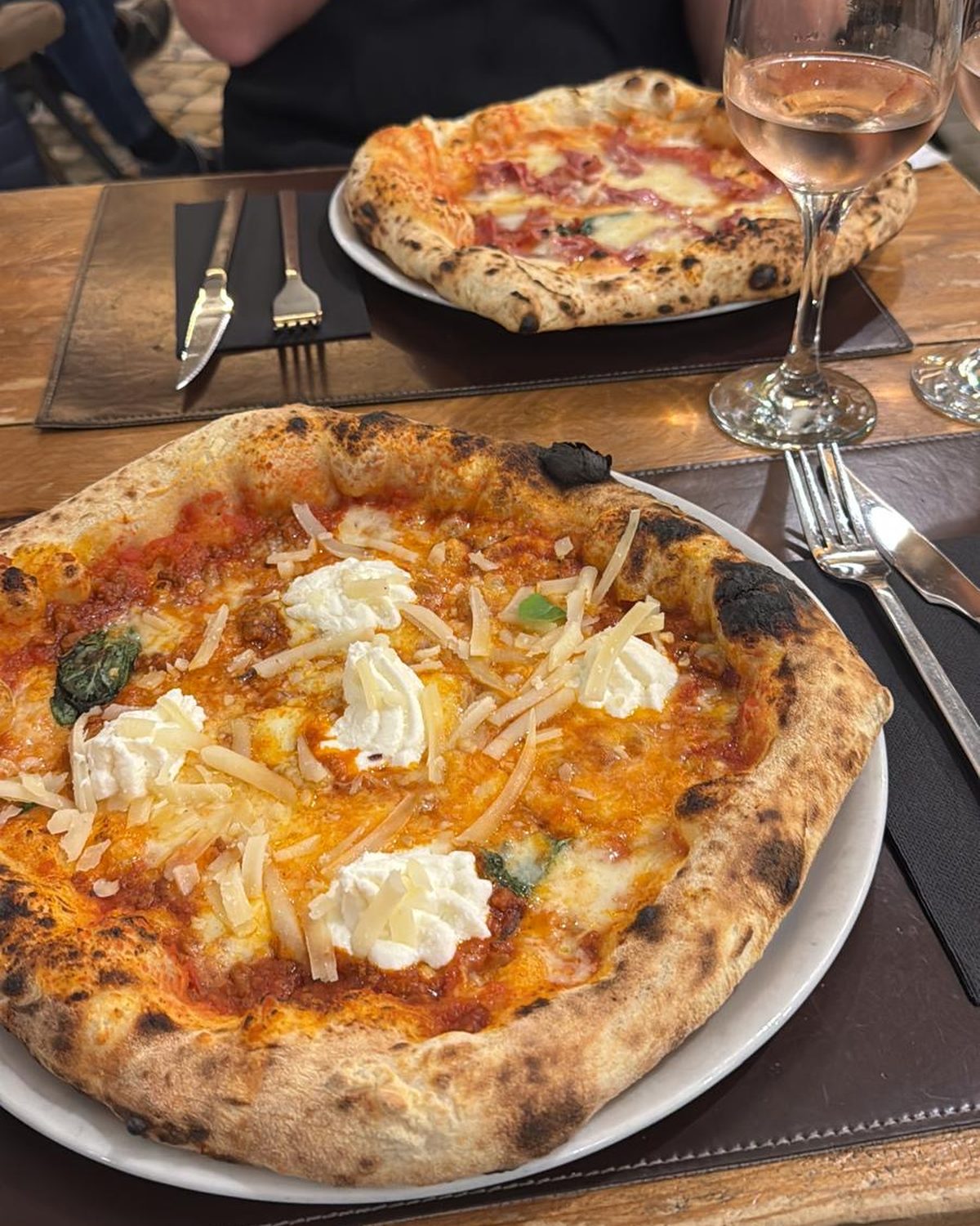 Twee pizza’s en een glas rosé op een tafel in Málaga